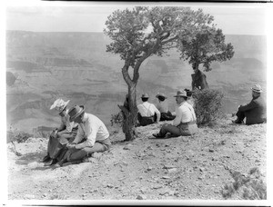 Eight hikers sitting on the Bright Angel Trail on the rim of the Grand Canyon, 1900-1940