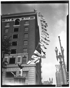 Flags on the side of the Chamber of Commerce building during Foreign Trade Week, Los Angeles, February 1928