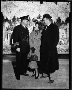 Two men and a woman standing on "Hollywood Santa Claus Lane"