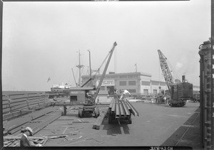 Steel beams being loaded on a truck, Los Angeles Harbor, September 17, 1930