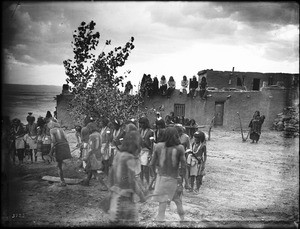 Snake priests in the Hopi Snake Dance Ceremony circling in front of the kisi and stamping on a plank with their right foot, Oraibi, Arizona, ca.1898