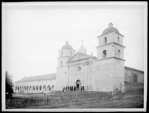 Mission Santa Barbara, California, showing group of about twelve people standing on front steps, ca.1888