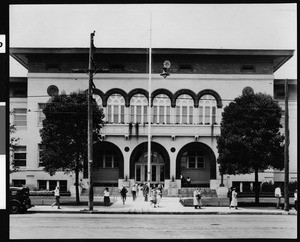 Exterior view of Manual Arts High School with students on the sidewalk