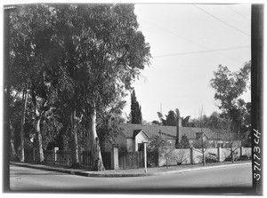 A building hidden by a fence and trees