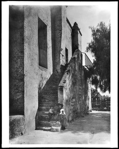 Children by the stone steps to the choir of Mission San Gabriel, ca.1904