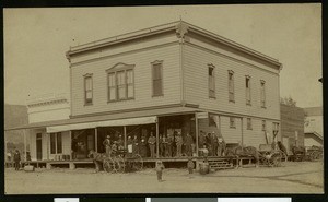 Group of people standing on the porch of the Baxter Block building at the corner of Lemon Avenue and Myrtle Avenue, 1886