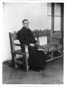 Plaza Church priest Reverend Joachim Adam, sitting on a bench, Los Angeles, ca.1890-1900