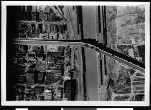 Aerial view of a flooded area, showing a highway over the river, 1938