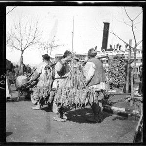 Vendors carrying straw sandals in China, ca.1900