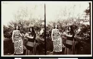 Two young Walapai indian women in front of a tree