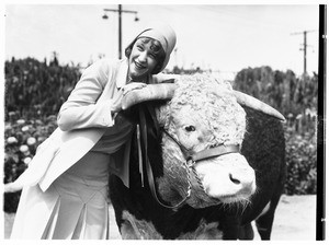 A woman posing with an ox