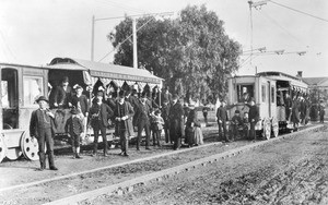 Portrait of passengers, conductors and engineers posing near Pico Boulevard Electric Railroad cars, Los Angeles, 1887