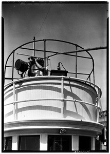 Close-up of a ship, showing a man with binoculars above the central cabin, May 1936