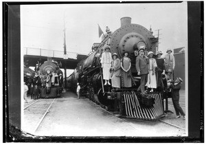 Frank Wiggins and tourists on the cowcatcher of a train