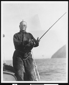 A man "sword fishing" (fishing for sword fish?) on a boat, ca.1930