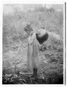 Young Havasupai Indian girl carrying an "Esua" on her back, ca.1900