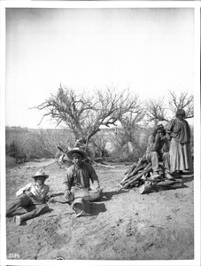 Three young Apache Indian men and a woman at an Apache Indian camp, 1903