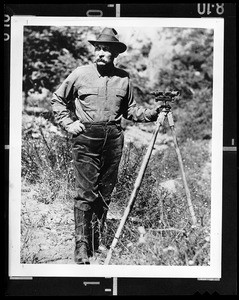 Portrait of William Mulholland with a surveyor's scope on a tripod, ca.1908-1913