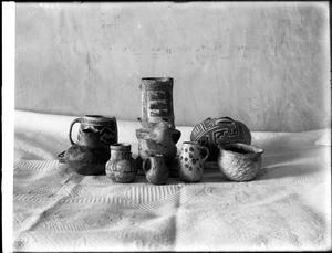 Collection of nine pieces of prehistoric Navajo Indian pottery on display, ca.1900