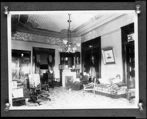 Woman sitting on a chair inside the Shatto residence, ca.1900