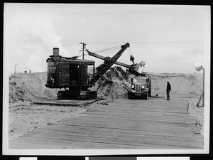 Steam shovel loading dirt into a truck