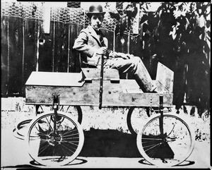 Portrait of Earle C. Anthony at a young age, sitting on a vehicle