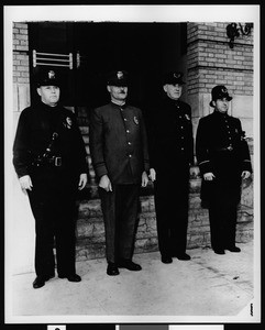 Four policemen modeling various styles of uniforms worn by the Los Angeles Police Department