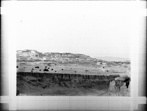 Pueblo of Laguna visible in the distance beyond a large natural basin or canyon, New Mexico, ca.1900