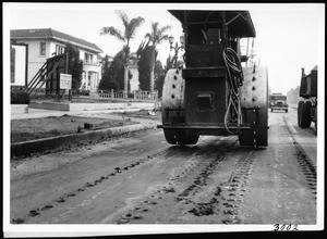 Roller tractor being used to perforatae old asphalt pavement on Sunset Boulevard to facilitate removal