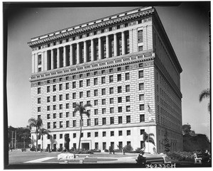 Exterior view of the Hall of Justice, showing people on benches