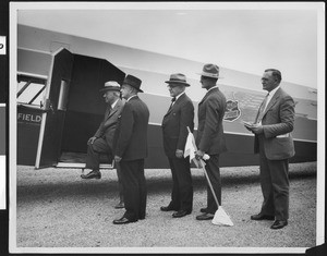 Five men outside a plane, showing one man boarding, ca.1930