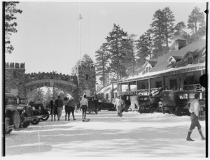 People and automobiles near the arch-entrance to Big Pines Recreational Camp