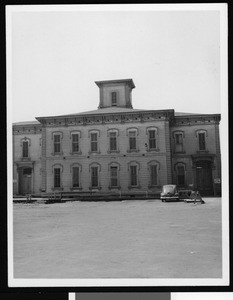 Exterior view of the old Los Angeles High School on Fort Moore Hill, showing an automobile in front, 1949