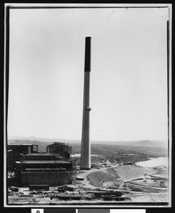 Massive smokestack beside the exterior of an unidentified factory, ca.1950