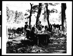 Eight people eating a picnic at Camp Number 3 in Yosemite Valley, ca.1900