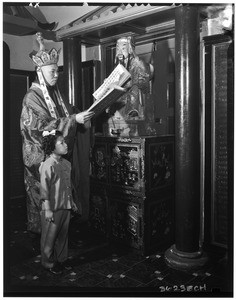 Buddhist priest and child in front of a religious statue (?), Chinatown