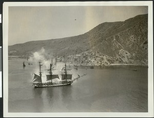 "Old Ironsides" replica in a staged sea battle used for a motion picture, showing small village in background clearly in view, ca.1926