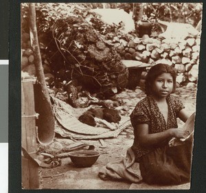 Indian woman sitting on the ground with what appears to be a bowl in her hands, ca.1900