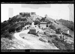 Exterior view of Lick Observatory on Mount Hamilton in Santa Clara, showing other buildings and a horse pen in the foreground, 1890-1899