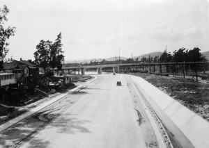 View of a street headed towards a concrete and wood viaduct in Los Angeles