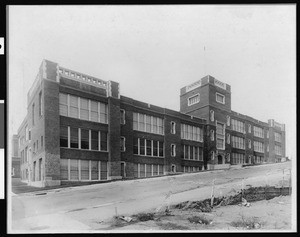 Exterior view of an unknown school behind a street on an incline