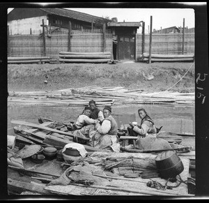 Four dock workers eating lunch on a river boat, ca.1900