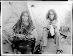 Hopi Indian husband and wife sitting outside, ca.1900