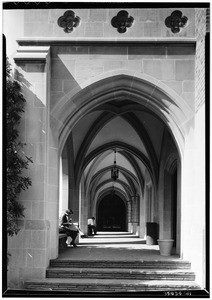 People sitting in an arch-lined hallway at the University of California at Los Angeles, February 1938