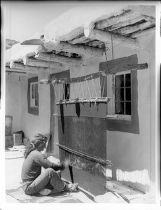 Hopi man (from his right side) weaving a rug, in the village of Shonguapavi, ca.1901