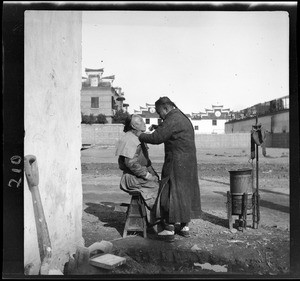 Chinese barber shaving a customer, China, ca.1900