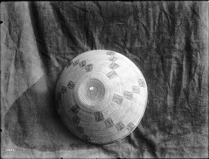 Indian basket displayed against a cloth backdrop, ca.1900