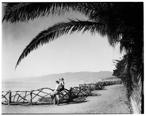 Santa Monica Palisades scene with girls on a rustic railing, 1928