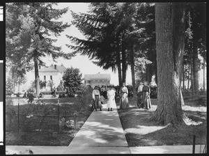 Exterior view of a group of young men and women standing outside the Indian Training School in Chemawa, Oregon, ca.1900