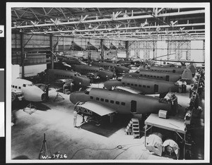 Planes (Lockheed 14 Super Electra?) in rows inside an unidentified aircraft manufacturing factory, ca.1940